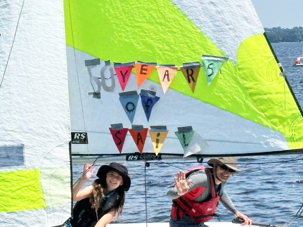 Two people cruise by in a sailboat.