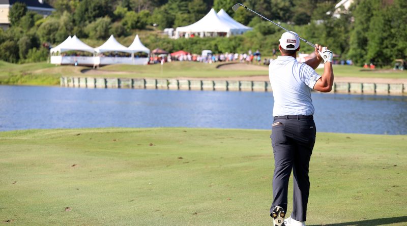 A golfer watches his shot.