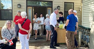 A man speaks to residents on a patio.