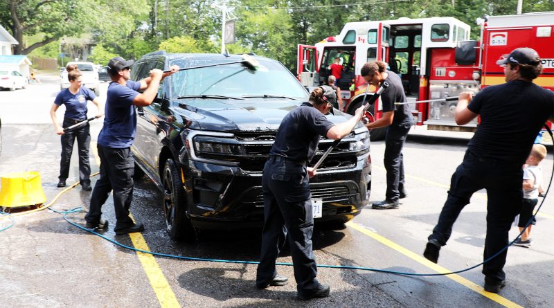 Firefighters wash a car.