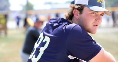 A ball player watches a game.