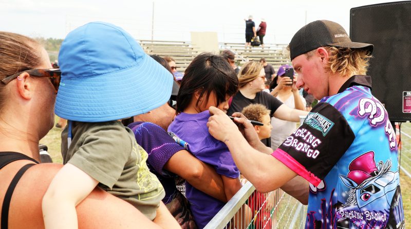 A man signs autographs.