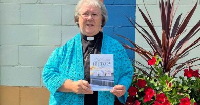 A reverend holds her book.