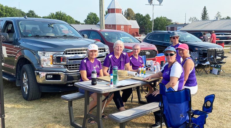A group enjoy bingo outdoors.
