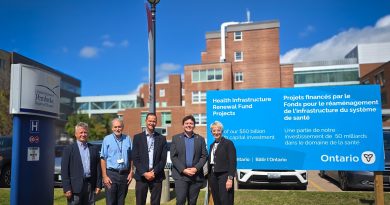 People pose in front of a hospital.