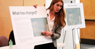 A woman holds a poster board.