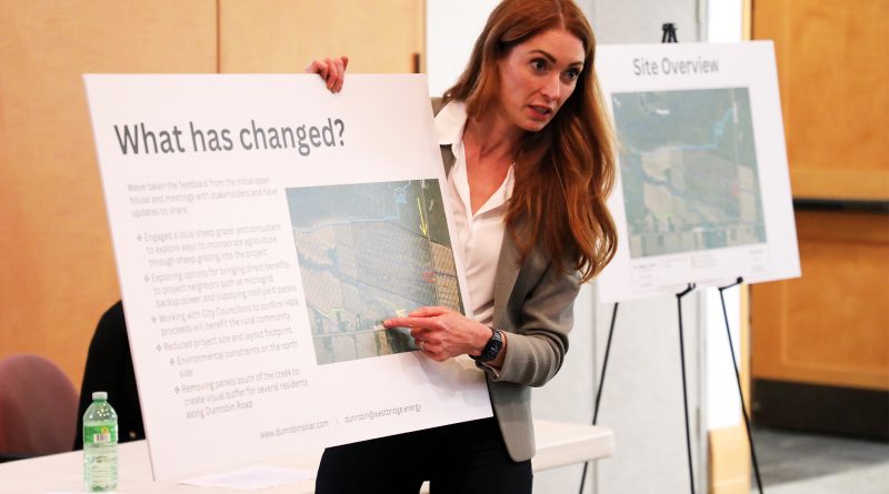 A woman holds a poster board.