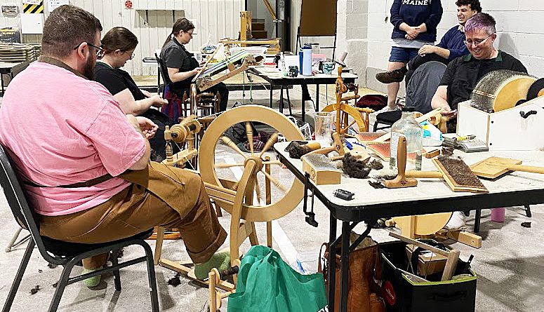 A photo of a team weaving a shawl.