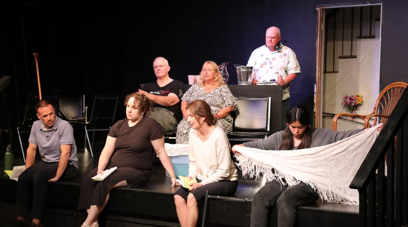 A group of people sit on a stage.