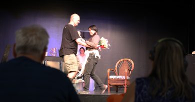 Two people watch another couple dance.