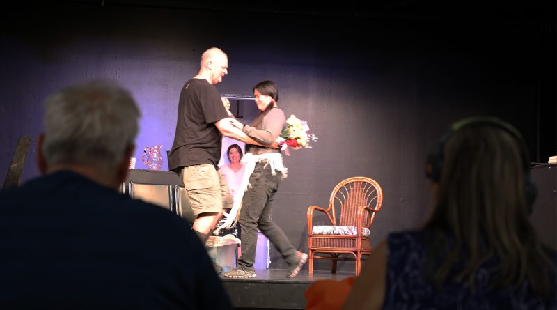 Two people watch another couple dance.