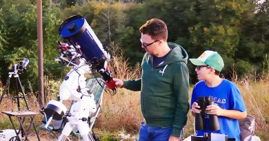 A dad and his son look through a telescope.