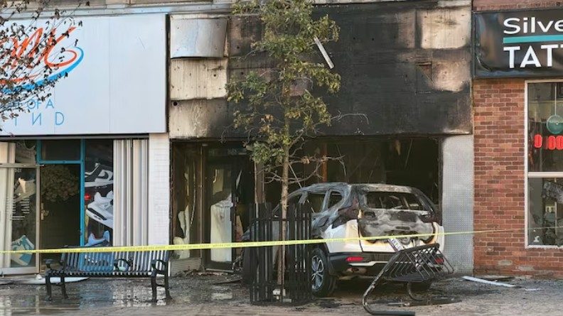 A photo of a car crashed in to a store.
