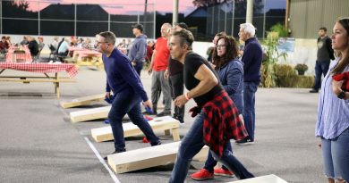 A photo of people playing cornhole.