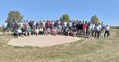 A group of golfers pose for a photo.