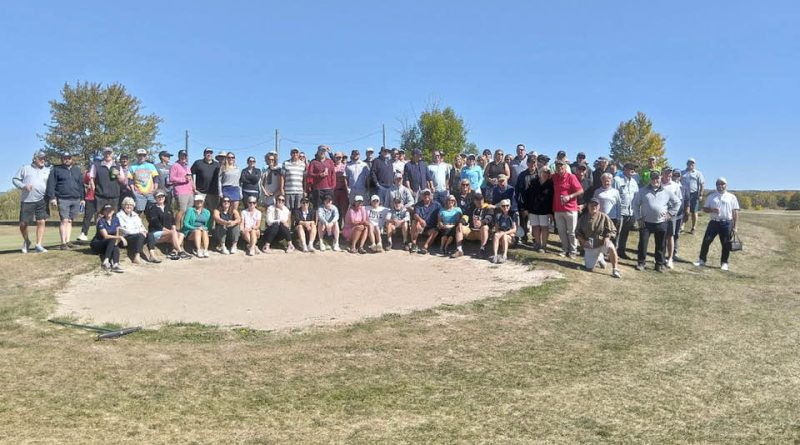 A group of golfers pose for a photo.