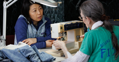 A photo of a woman sewing.