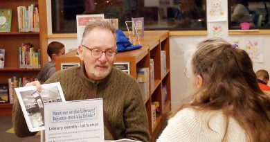 Two people talk in a library.