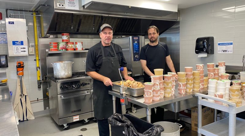 A photo of two cooks in a kitchen.