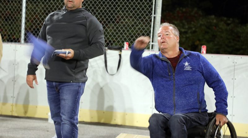 A photo of a person playing cornhole.