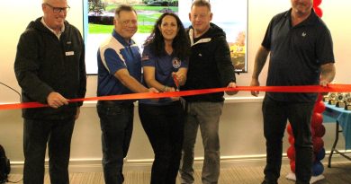 WC opens first baseball field A group of people cut a ribbon.