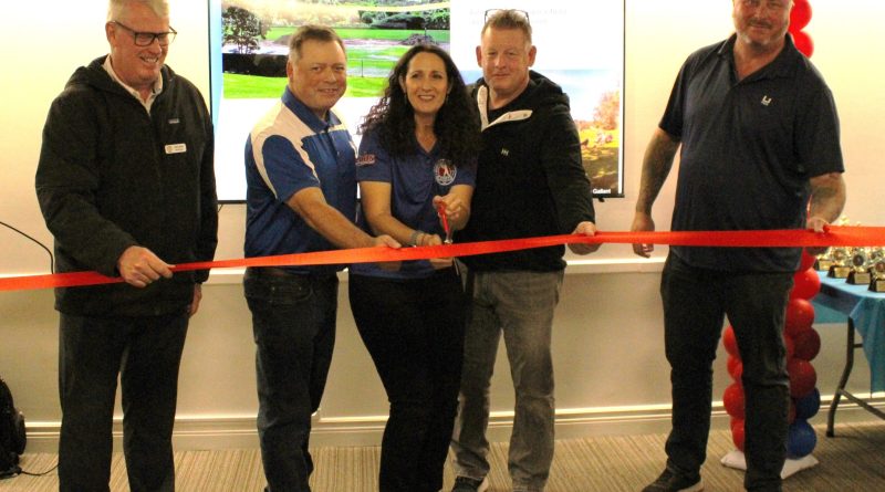 A group of people cut a ribbon.
