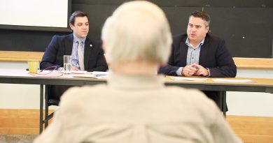 WC budget priority roads again Two people speak in a room.