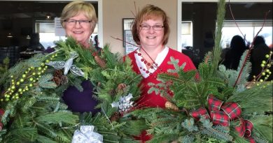 A photo of people holding wreaths.