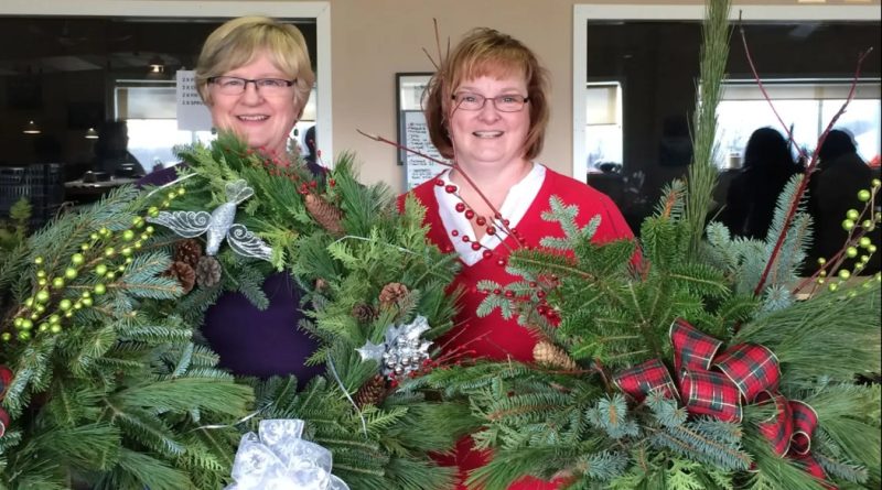 A photo of people holding wreaths.