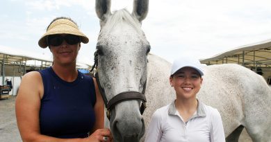Two people and a horse pose for a photo.