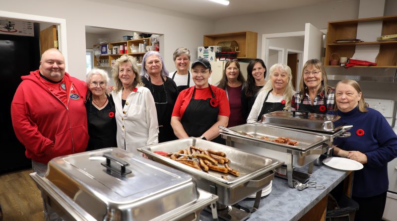 A group of ladies pose in front of breakfast.