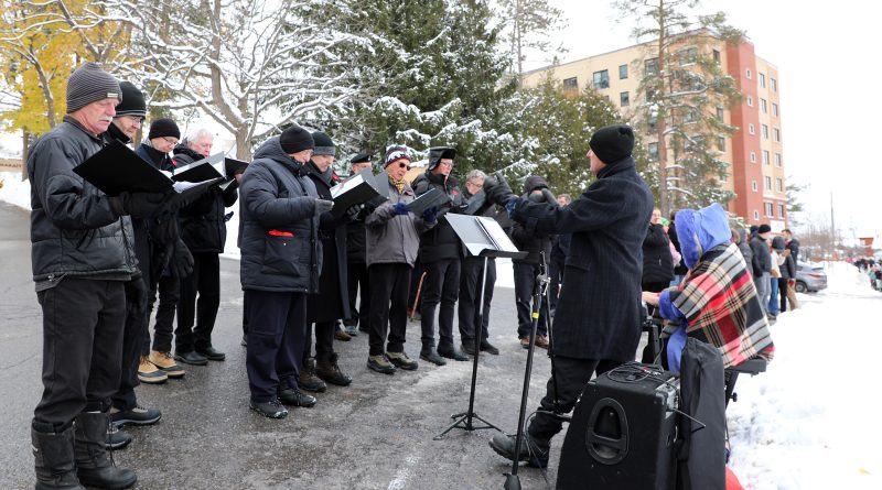 A chorus performs outside.