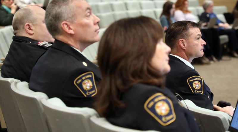 Four firefighters watch a presentation.