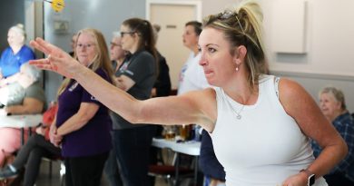 A woman throws a darts.