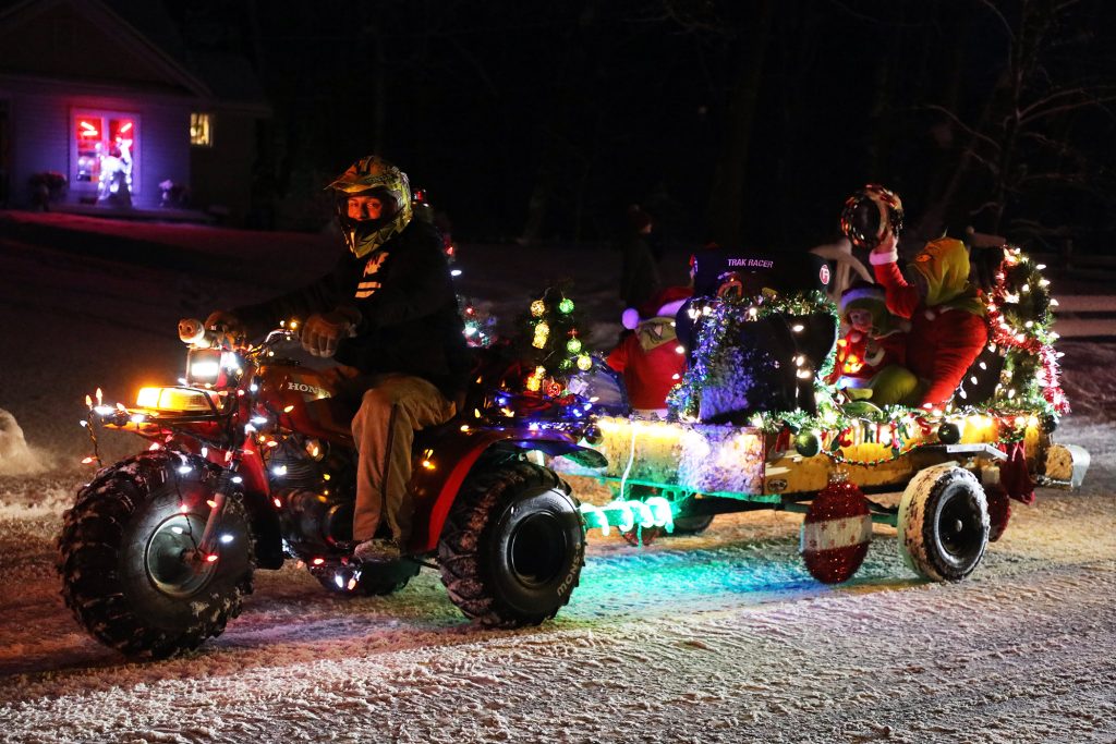 A three wheeler tows some kids.