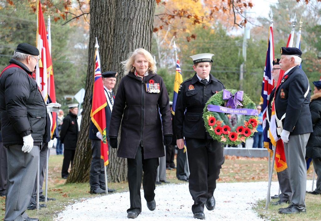 A woman lays a wreath on Remembrance Day.
