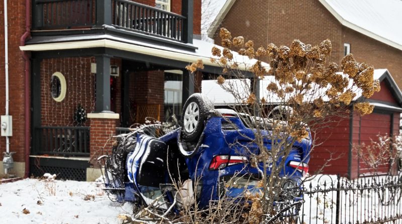 A photo of a car on its roof on a lawn.