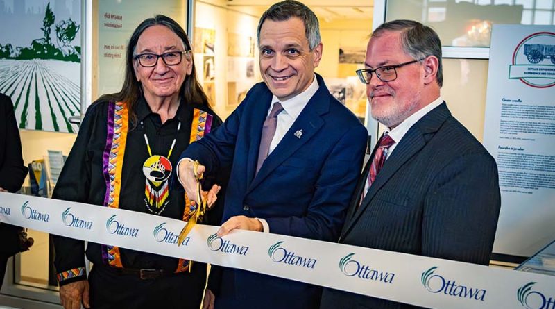 Three people cut a ribbon.