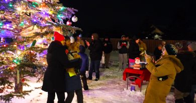 People take a photo in front of a tree.