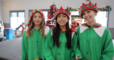 Three elves pose for a photo.