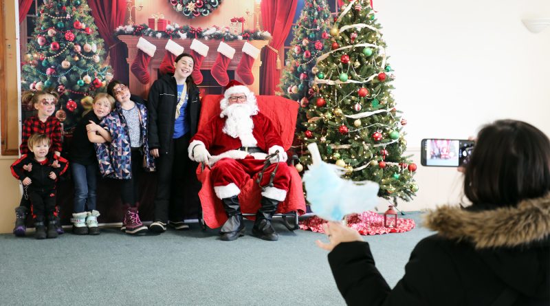 A group of kids pose with santa.