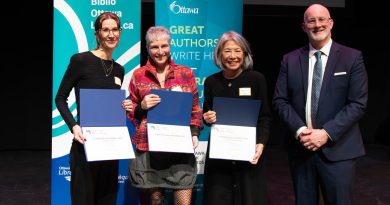 Three people pose with awards.