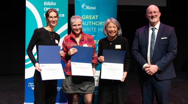 Three people pose with awards.