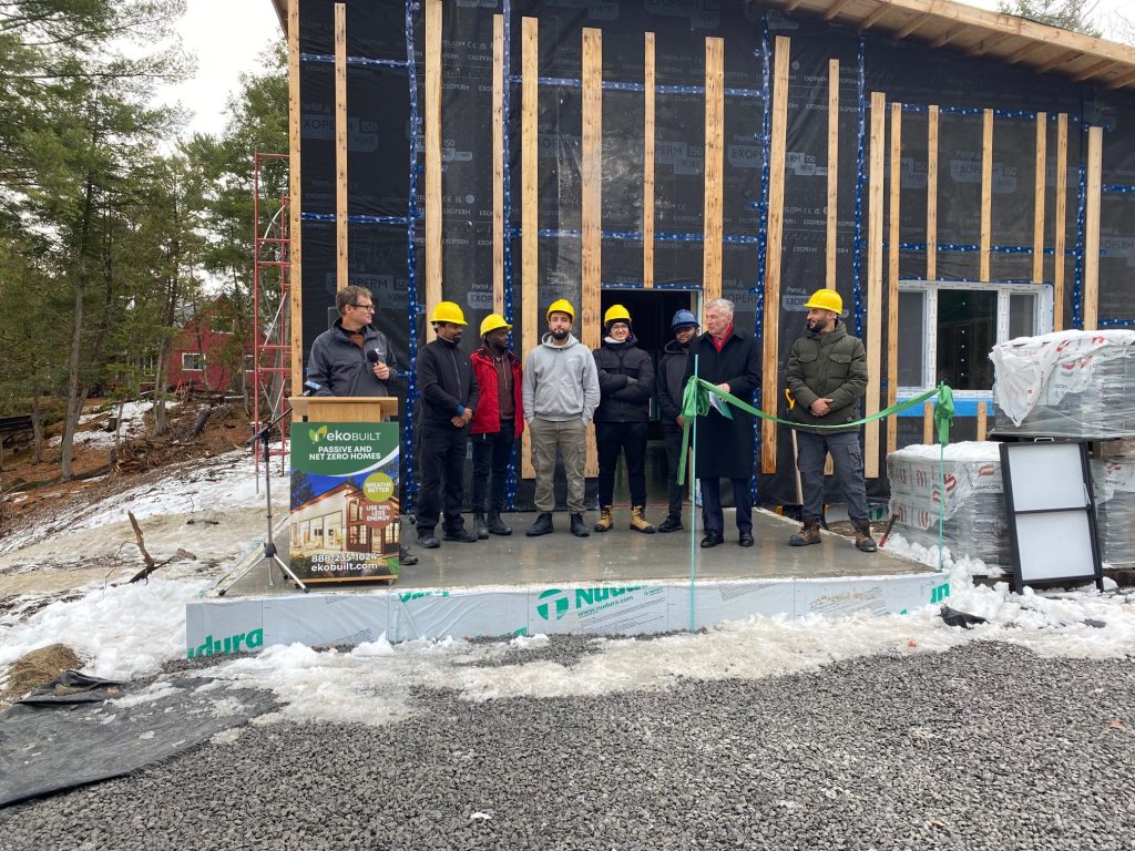 A group of builders pose in front of a home.