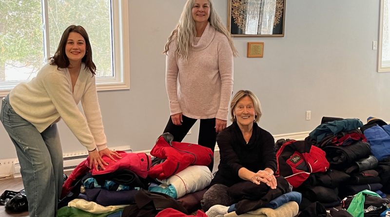 A group of people sort through clothing.