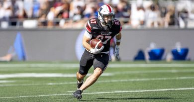 A man runs with a football.