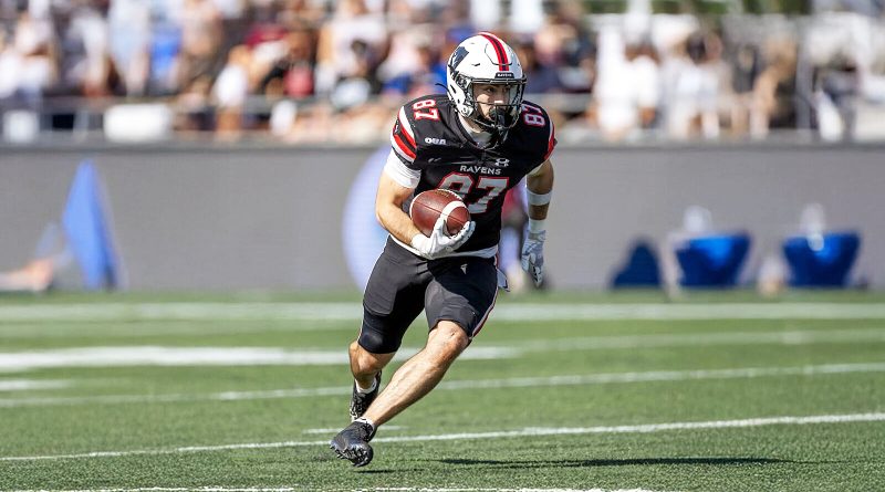 A man runs with a football.