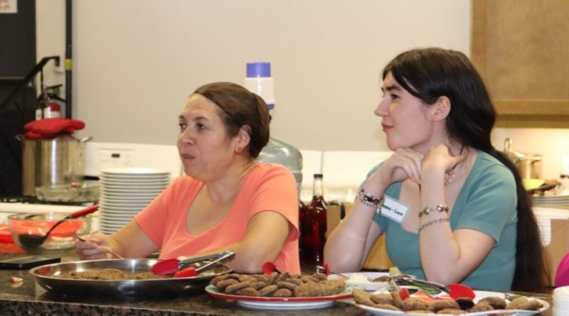 Two people in front of food.