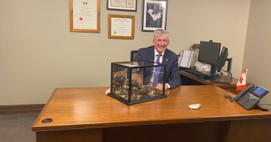 A man poses at his desk.