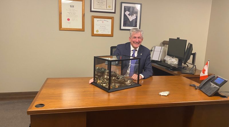 A man poses at his desk.